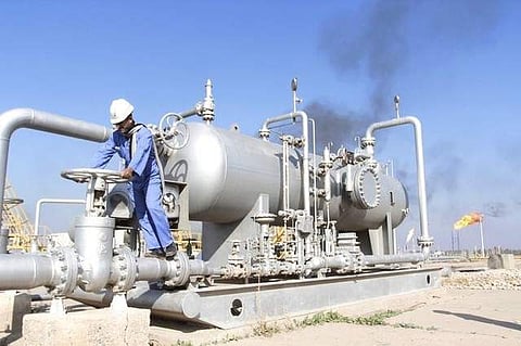 A worker checks the valve of an oil pipe at Nahr Bin Umar oil field, north of Basra, Iraq December 21, 2015. | Reuters