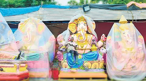 Vendor sits atop massive PoP Ganesha idol in Pottery Town. | Pandarinath B