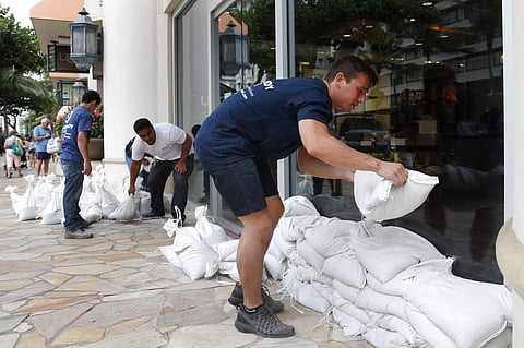 People stacks sandbags in front of a closed store in preparation for Hurricane Lane, Thursday, Aug. 23, 2018, in Honolulu. ( Photo | AP)