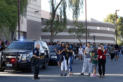 Students and parents wait outside Canyon Springs High School in North Las Vegas after a fatal shooting near a school ball field. ( Photo | AP)