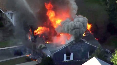 In this image take from video provided by WCVB in Boston, flames consume the roof of a home in Lawrence, Mass, a suburb of Boston. (AP)