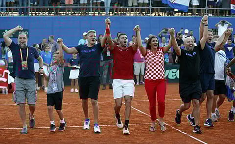 Croatia's Borna Coric (C) celebrates with his team after defeating Frances Tiafoe of the United States in their Davis Cup semifinal singles match | AP