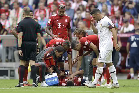 Bayern Munich midfielder Corentin Tolisso lies injured on the ground during the German Bundesliga soccer match against Bayer Leverkusen. | AP