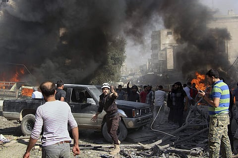 Defense workers and Syrian citizens gather after an airstrike hit a market in Maaret al-Numan in southern Idlib, Syria. (Photo | (Syrian Civil Defense White Helmets via AP)