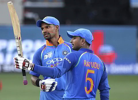 India's centurion Shikhar Dhawan (L) watches as teammate Ambati Rayudu raises his bat to celebrate scoring fifty | AP