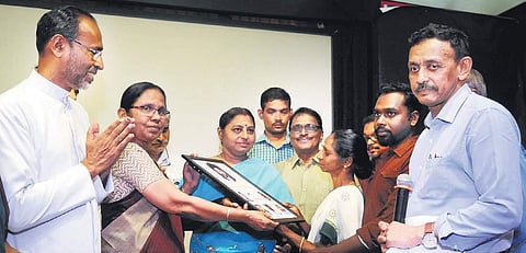 Health Minister K K Shailaja and hand recipient Lingashelvi hands over the memento to Arunraj's mother Sita as Fr Davis Chirammel and Dr Subramania Iyer look on | A Sanesh