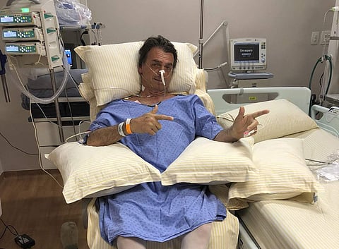 Presidential candidate Jair Bolsonaro poses for a photo while sitting in his hospital room at the Albert Einstein Hospital, in Sao Paulo | AP