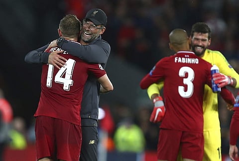 Liverpool's coach Juergen Klopp hugs Liverpool's Jordan Henderson after the Champions League Group C soccer match between Liverpool and Paris-Saint-Germain at Anfield stadium in Liverpool, England, Tuesday, Sept. 18, 2018. | AP