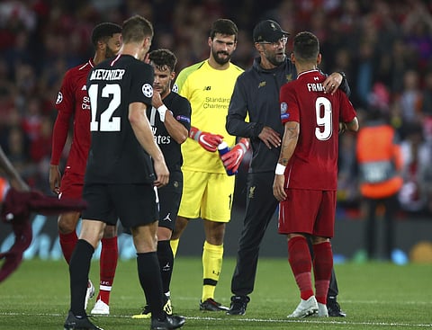 Liverpool's coach Juergen Klopp hugs Liverpool's Roberto Firmino at he end of the match after he scored his sides third goal during the Champions League Group C soccer match between Liverpool and Paris-Saint-Germain at Anfield stadium in Liverpool, Englan