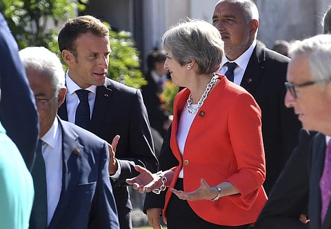 French President Emmanuel Macron (L) talks with British Prime Minister Theresa May when arriving for a family photo at the informal EU summit in Salzburg, Austria | AP