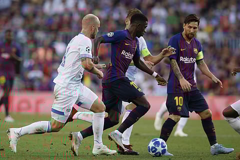Barcelona forward Ousmane Dembele, center, controls the ball as PSV's Jorrit Hendrix, left, tries to stop him during the group B Champions League soccer match between FC Barcelona and PSV Eindhoven at the Camp Nou stadium in Barcelona, Spain, Tuesday, Sep