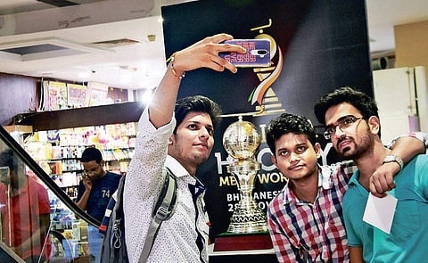 Youths click selfie with Odisha Hockey World Cup trophy replica at a shopping mall in Bhubaneswar on Wednesday | Express