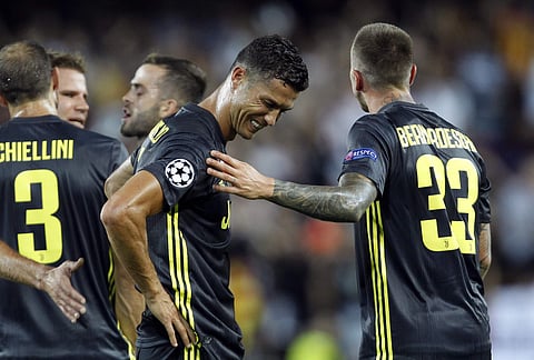 Juventus forward Cristiano Ronaldo is consoled by teammate Federico Bernardeschi, right, after receiving a red card during the Champions League, group H soccer match between Valencia and Juventus, at the Mestalla stadium in Valencia, Spain, Wednesday, Sep