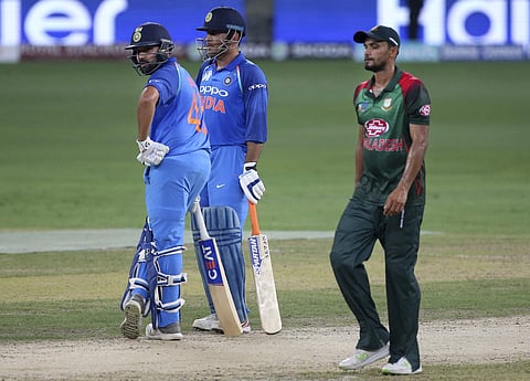 Bangladesh's captain Mashrafe Mortaza walks past India's captain Rohit Sharma (L) and MS Dhoni during the Asia Cup ODI match | AP