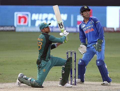 Pakistan's Shoaib Malik, left, watches the ball after hitting a six during the one day international cricket match of Asia Cup between India and Pakistan in Dubai. (AP)
