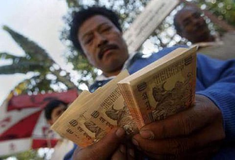 An Indian counts currency notes in front of the Reserve Bank of India in Gauhati, India, Tuesday, Nov. 22, 2011. (Photo | Associated Press)