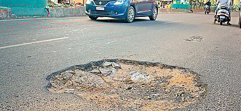 A pothole-ridden road near Ulsoor on Sunday; (below) workers undertake asphasting work on a road | Pandarinath B