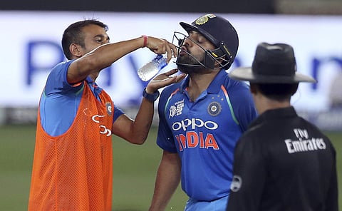 A reserve player feeds water to India's captain Rohit Sharma during the ODI cricket match of Asia Cup between India and Pakistan in Dubai | AP