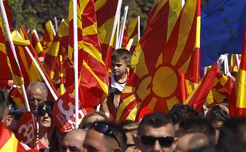A boy is lifted up as people wave Macedonian and EU flags during a rally in downtown Skopje, Macedonia, Sunday, Sept. 16, 2018. (Photo | AP)