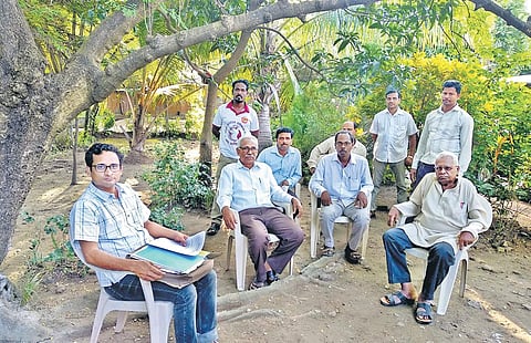 Kaka Kalu Ram Dhodade (right), a tribal rights activist, meeting villagers whose land is poposed to be acquired | RICHA SHARMA
