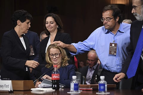 Christine Blasey Ford is patted on the head by Keith Kogner as she finishes testifying to the Senate Judiciary Committee on Capitol Hill in Washington, Sept. 27, 2018. (Photo | AP)