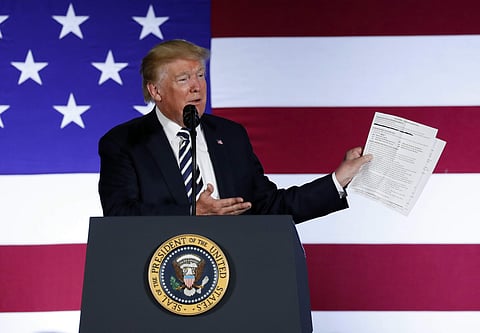 President Donald Trump holds up a list of his administrations accomplishments while speaking at a Republican fundraiser. (Photo | AP)
