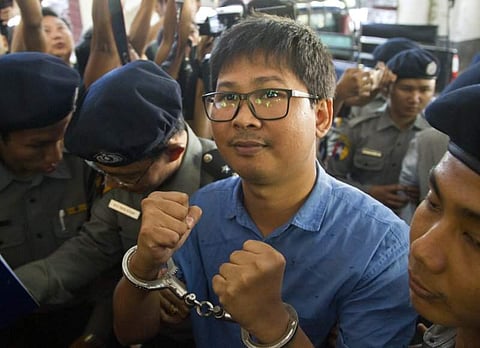 Reuters journalist Wa Lone is escorted by police as he leaves court outside Yangon, Myanmar. (Photo | AP)