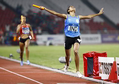 VK Vismaya crosses the finish line to win the women's 4x400m relay final at the athletics competition at the 18th Asian Games in Jakarta (Photo | AP)
