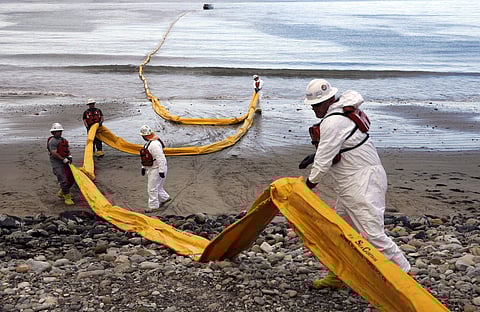 In this May 21, 2015, file photo, workers prepare an oil containment boom at Refugio State Beach, north of Goleta, Calif., two days after a ruptured pipeline created the largest coastal oil spill in California in 25 years. A California jury has found a pi