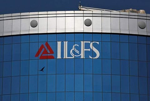 A bird flies next to the logo of IL FS (Infrastructure Leasing and Financial Services Ltd.) installed on the facade of a building at its headquarters in Mumbai, September 25, 2018. | Reuters