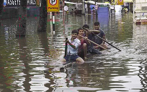 Residents row a makeshift boat to cross a flood-affected area following heavy monsoon rainfall in Patna. (Photo | PTI)