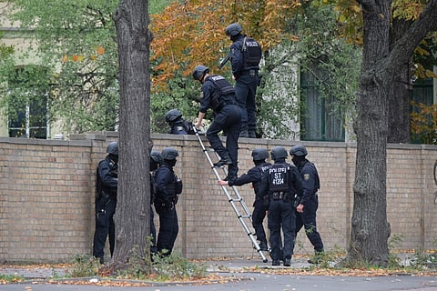 Police officers cross a wall at a crime scene in Halle, Germany, Wednesday, Oct. 9, 2019 after a shooting incident. (Photo | AP)