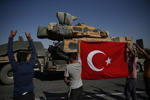 Local residents applaud as a convoy of Turkish forces trucks transporting tanks pass near Syria border. (Photo|AP)