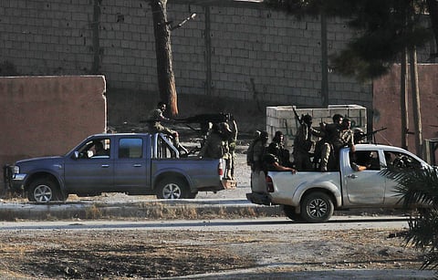 In this photo taken from the Turkish side of the border between Turkey and Syria, in Akcakale, Sanliurfa province, southeastern Turkey, Turkish-backed Syrian opposition fighters on pick-up trucks celebrate as they drive in Tal Abyad, Syria (Photo| AP)