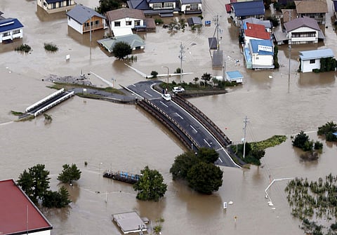 Cars are stranded on a road as the city is submerged in muddy waters after an embankment of the Chikuma River broke, in Nagano, central Japan, Sunday, Oct. 13, 2019. (Photo | AP)