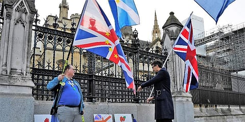 A pro-Brexit supporter, left, and an anti-Brexit supporter, right, talk outside the Houses of Parliament in London. (Photo | AP)