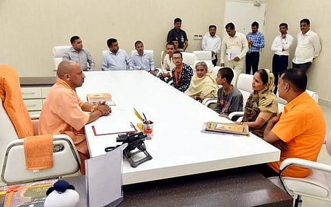 Uttar Pradesh CM meets with kin of slain Hindu outfit leader Kamlesh Tiwari in Lucknow on Sunday. (Photo | Twitter/@CMOfficeUP)