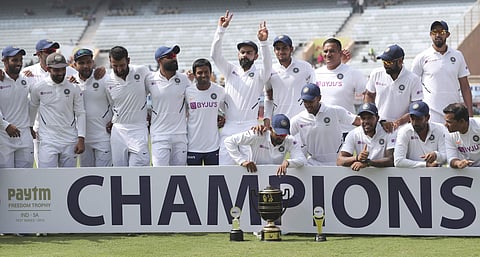 Members of Indian team pose with the winners trophy as captain Virat Kohli, center, flashes victory sign. (Photo | AP)