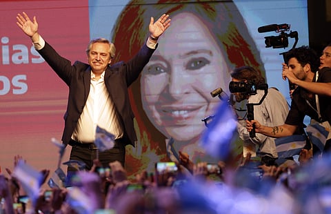 Peronist presidential candidate Alberto Fernández waves to supporters in front of a large image of his running mate, former President Cristina Fernández, after incumbent President Mauricio Macri conceded defeat at the end of election day in Buenos Aires,