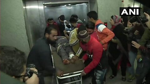 An injured civilian being shifted to the hospital after a grenade attack near a bus stand at Shopian. (Photo | Twitter/ANI)