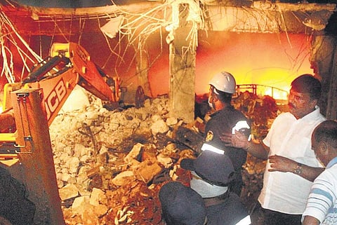 Fire department officials try to put out the fire which broke out in a tyre godown near Vanasthalipuram in Hyderabad on Sunday