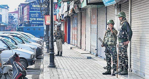 Security personnel stand guard during restrictions in Srinagar on Monday. (Photo | PTI)