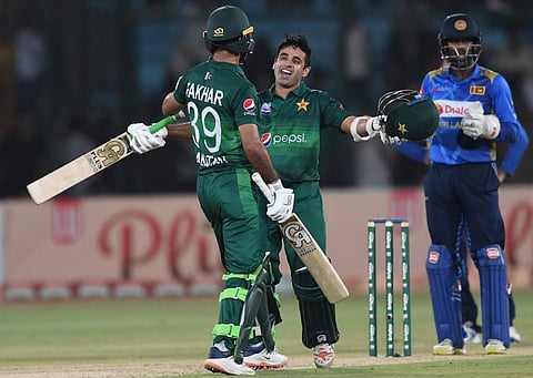 Pakistan's batsman Abid Ali (C) celebrates with teammate Fakhar Zaman (L) after scoring 50 runs as Sri Lanka's wicketkeeper Minod Bhanuka looks on during the third and final one day international (ODI) cricket match between Pakistan and Sri Lanka in Karac
