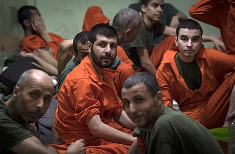 Men, suspected of being affiliated with the Islamic State (IS) group, gather in a prison cell in the northeastern Syrian city of Hasakeh. (Photo | AFP)