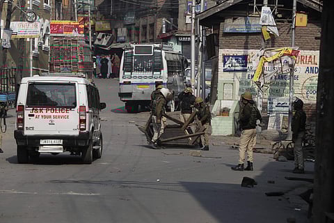Policemen remove road blocks put up by protesters in Srinagar (Photo| AP)