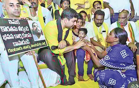 Nara Lokesh speaks to a construction worker during TDP deeksha on sand scarcity, in Guntur on Wednesday I Express