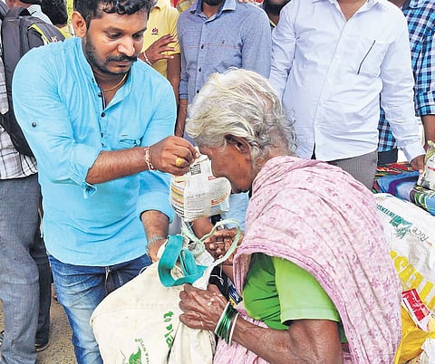 A Mana Peddapuram member distributing rice to an eldery lady | Express