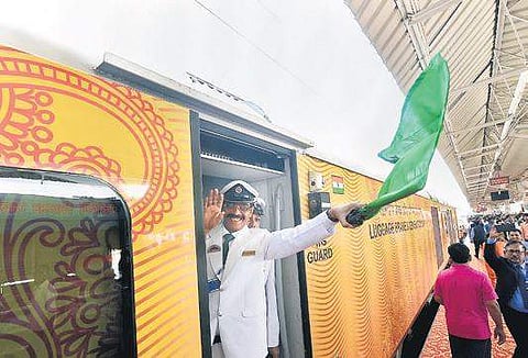 The guard of the Lucknow-Delhi Tejas Express waves the green flag from the Charbagh station in Lucknow. ( Photo | PTI )