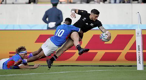 New Zealand's T J Perenara looks to score a try as he is tackled by Namibia's Helarius Kisting during the Rugby World Cup Pool B game at Tokyo Stadium. (Photo | AP)