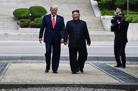 North Korea's leader Kim Jong Un walks with US President Donald Trump north of the Military Demarcation Line that divides North and South Korea, in the Joint Security Area (JSA) of Panmunjom in the Demilitarized zone (DMZ) (Photo | AFP)